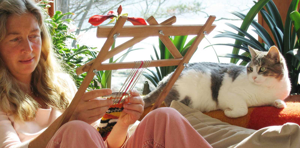 woman weaving with cat on couch
